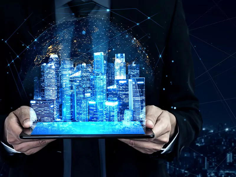 person holding a tablet and a hologramic image of a smart city is hovering over it