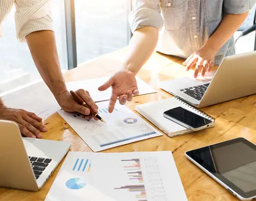 two people pointing to a chart and discussing